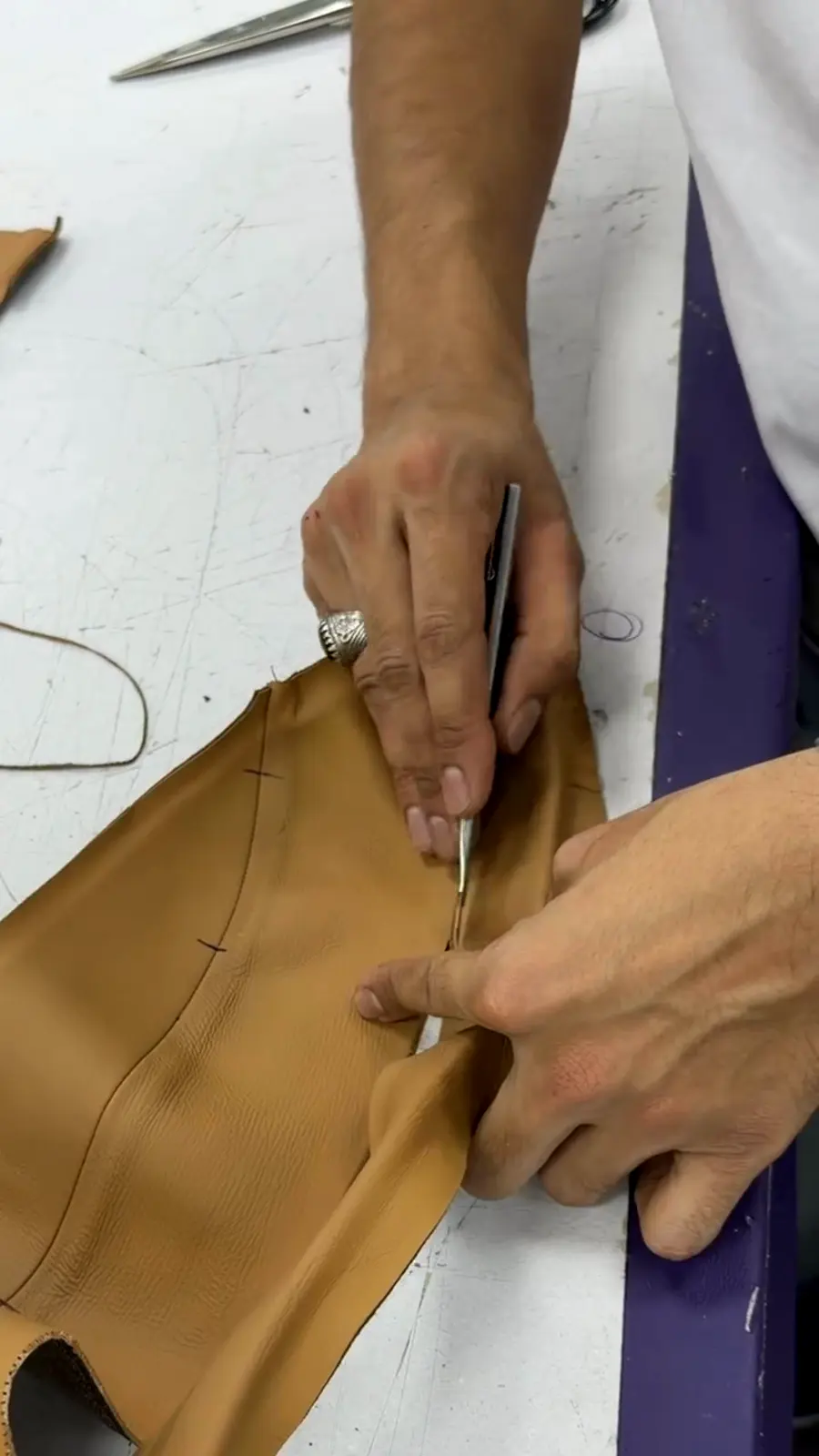 Hands cutting and skiving leather by hand in the HM Atelier workshop, Dubai